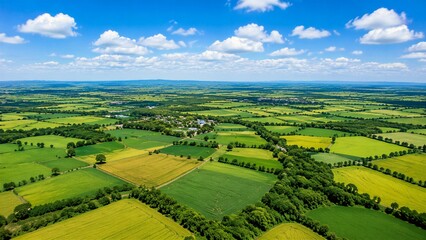 Fototapeta premium Aerial view of patchwork farmland under blue sky on sunny summer day