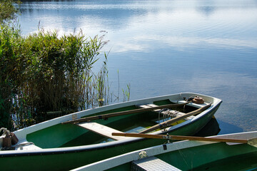 Green rowing boats on the shore of Hopfensee lake in the Allgäu region, Bavaria, Germany © Robin