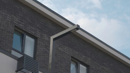 Obraz premium Low Angle View of Modern Brick Building Facade with Streetlight