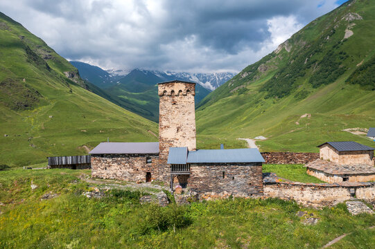 Lamaria Church and medieval Svan tower in Ushguli, UNESCO World Heritage site in Upper Svaneti, Georgia, dramatic Caucasus mountains and alpine valley landscape.