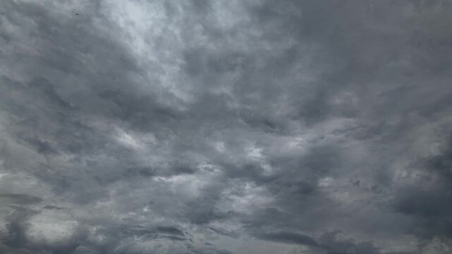 Heavy dark storm clouds covering entire sky, threatening weather before rain, moody grey cloudscape, 4K timelapse frame, nature background.