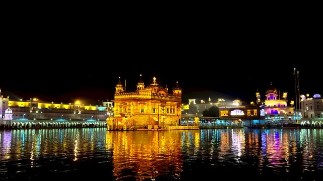 Wide View of Golden Temple at Night with Glowing Reflection on Water, Harmandir Sahib, Amritsar, Punjab, India