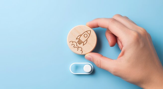 Hand holding a wooden circle with a rocket icon
