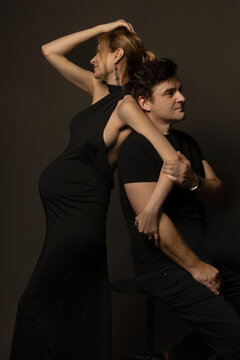 A pregnant slim girl poses with her husband in black outfits