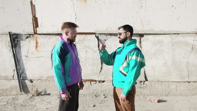 Confrontation Against Urban Backdrop. Urban Scene With Confrontational Men And Vibrant Fashion Contrast . Media