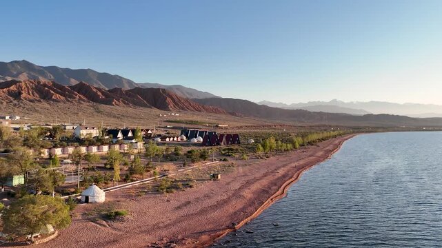 Stunning drone view of Issyk-Kul Lake at sunset, showcasing golden skies