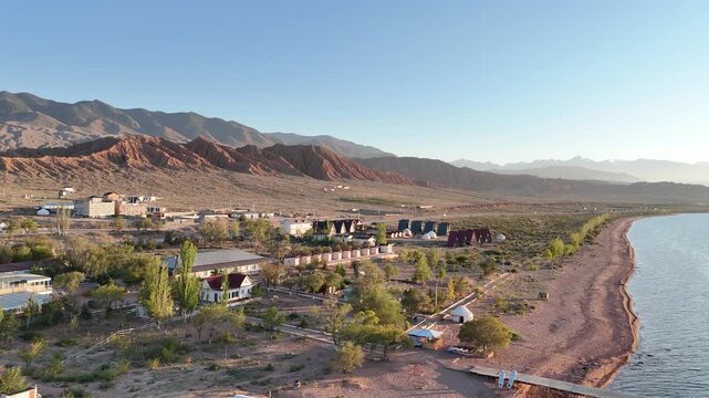 Stunning drone view of Issyk-Kul Lake at sunset, showcasing golden skies