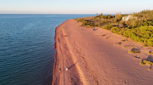 Stunning drone view of Issyk-Kul Lake at sunset, showcasing golden skies