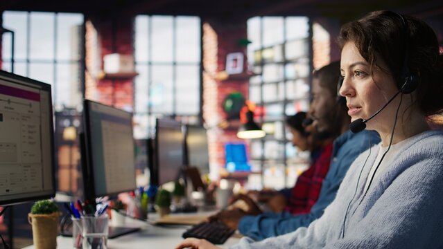 A call center agent handles inbound calls and customer inquiries, updates account records and works toward performance metrics in a close-up workplace scene during a busy office workday.