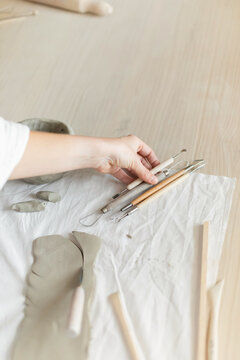 Creative clay pot on worktable with wooden handles and cloth, top-down