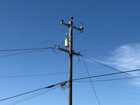 Electricity distribution pylon and power lines under blue sky