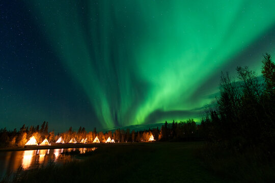 Amazing northern lights dancing over the light up Tipi or Tepees at Aurora Village in Yellowknife, Northwest Territories, Canada.