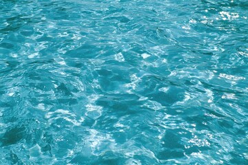Fototapeta premium Shimmering turquoise water surface, sparkling with light reflections
