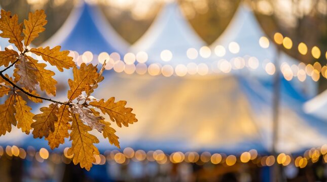 Autumn leaves on branch and blurred festival tent with bokeh lights background, copy space