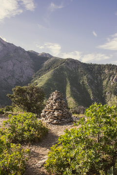 Stacked Rock Cairn Trail Marker on Hidden Valley Loop Trail via Taylor Canyon Above Ogden Utah in Summer with Wasatch Mountain Peaks Beyond