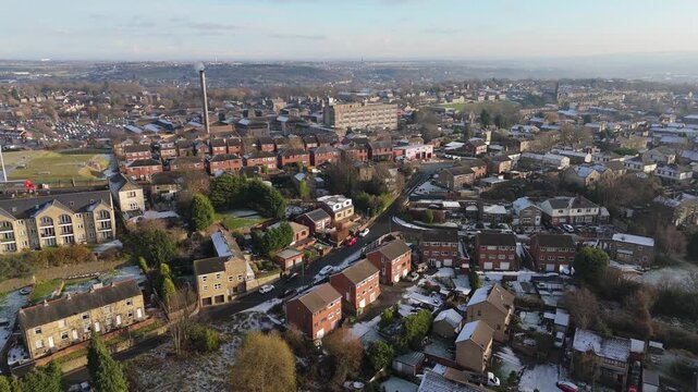Drone's-eye winter view captures Dewsbury Moore Council estate's typical UK urban council-owned housing development with red-brick terraced homes and the industrial Yorkshire. Working class housing