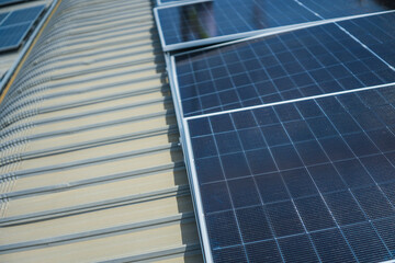 Fototapeta premium The completed solar array turns the old factory roof into a shining power plant, orderly on the sweeping metal roof of a manufacturing plant in Southeast Asia, during the fit out.