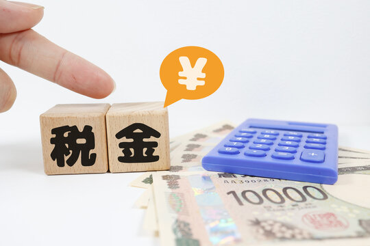 税金と1万円札。日本円記号。電卓とお金。ビジネス。白背景。