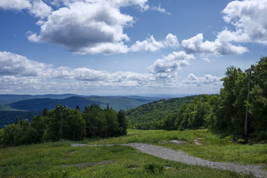 Paysage de montagne avec de l'herbe verte et un ciel bleu parsem&eacute; de nuages ​​blancs. Sommet de la montagne, for&ecirc;t et ciel bleu, Qu&eacute;bec, Canada.