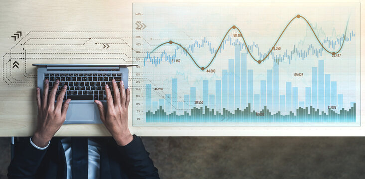 Hands typing on a laptop at a desk with financial graphs and charts displayed on the screen, highlighting data visualization trends and business insights. Scalp