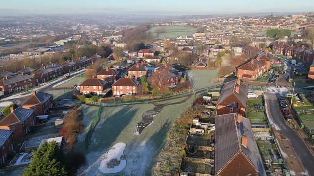 Drone's-eye winter view captures Dewsbury Moore Council estate's typical UK urban council-owned housing development with red-brick terraced homes and the industrial Yorkshire. Working class housing