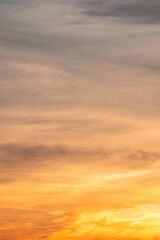 Fototapeta premium Sky sunset,Beautiful sunrise sky with vibrant gradient orange and gold colors and soft blue, Clear atmosphere with wispy clouds. Peaceful, perfect for background and copy space, vertical