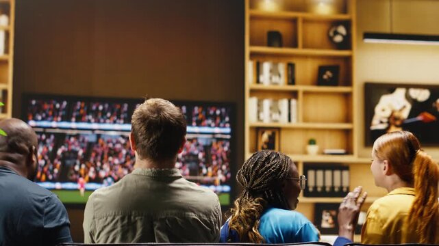 Football fans watch a tense football match from sofa, having frantic reactions to a missed chance on TV as supporters at home are agitated by referee decisions in a dramatic soccer game.