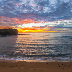 Obraz premium Sunrise Seascape with Calm Seas and a Cloud Covered Sky