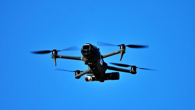Category C5 drone with a flight-termination parachute  for emergency deployment flying in clear blue sky