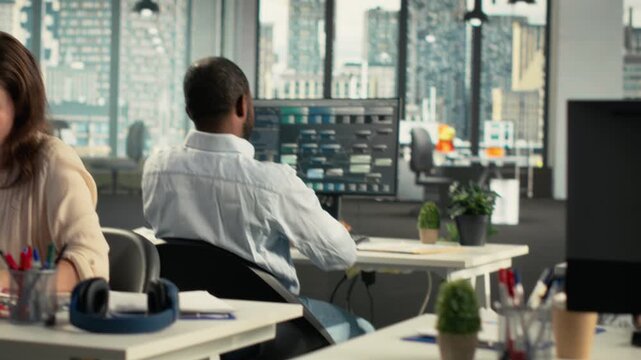 Company employees review forecasting data in a shared office, using forecasting data to connect analytics with management goals for a focused business workflow.