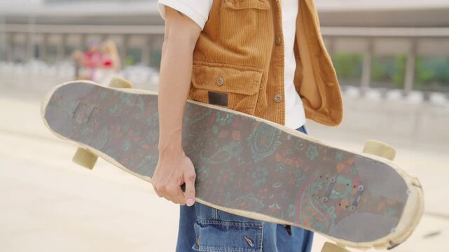 Portrait of Young Asian man holding longboard skateboard while skateboarding at urban public park enjoy active lifestyle outdoor healthy leisure activities extreme sport and modern city mobility