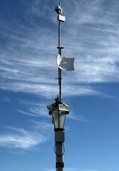 Fototapeta premium Security camera and antenna on top of a lamp on an ocean pier