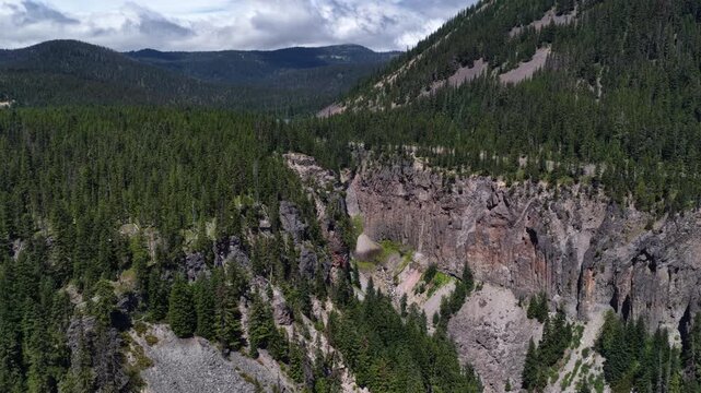 Aerial of North Fork Clear Creek river in canyon with waterfall in Washington with dramatic rock cliffs along US Highway 12