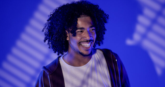 Cheerful young man laughing enjoying the moment against a blue background