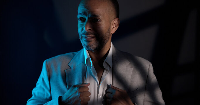 Man in a business suit expressing suspicion under cinematic lighting and shadows