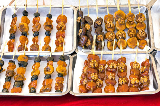 Dry sweet candy foods on skewer wooden sticks on plastic trays