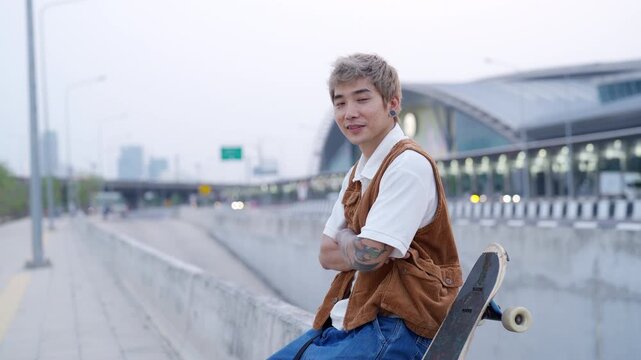 Portrait of Young Asian man holding longboard skateboard while skateboarding at urban public park enjoy active lifestyle outdoor healthy leisure activities extreme sport and modern city mobility
