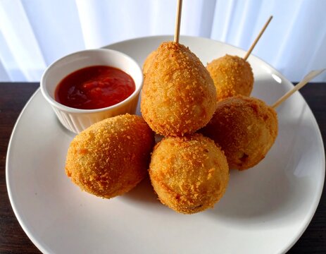 Delicious Indonesian Sempol Ayam, crispy fried chicken skewers on a white plate with chilli sauce