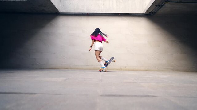 Young Asian woman practicing longboard skateboard on urban public park during late afternoon enjoy active lifestyle outdoor recreation balance fitness freedom healthy leisure and modern city mobility