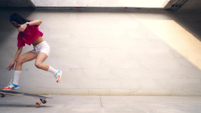 Young Asian woman practicing longboard skateboard on urban public park during late afternoon enjoy active lifestyle outdoor recreation balance fitness freedom healthy leisure and modern city mobility