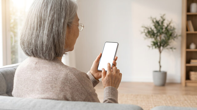画面をタッチしながらスマートフォンを操作するシニア女性の手元とバックグラウンド