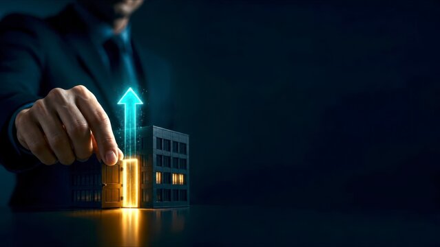 Business growth concept with hand touching small building and glowing upward arrow for business expansion and success