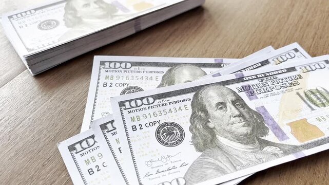 Stacked 100 dollar bills on a wooden table. Finance. Economy. 