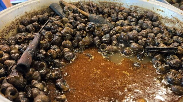 Tutut (freshwater snails) cooked in a pot, ready to be eaten.