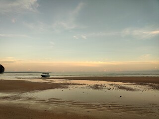 Obraz premium Low Tide Beach with Traditional Boat at Ora Beach, Maluku, Indonesia