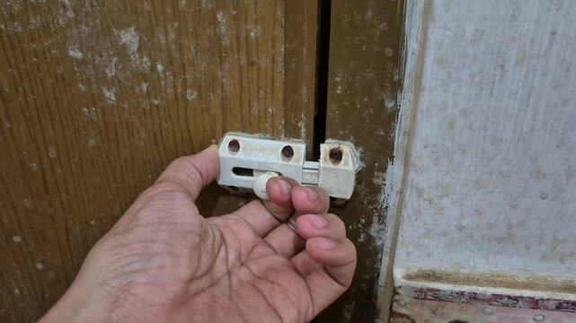 activity of trying to open a 2 inch PVC plastic bathroom door latch with one hand