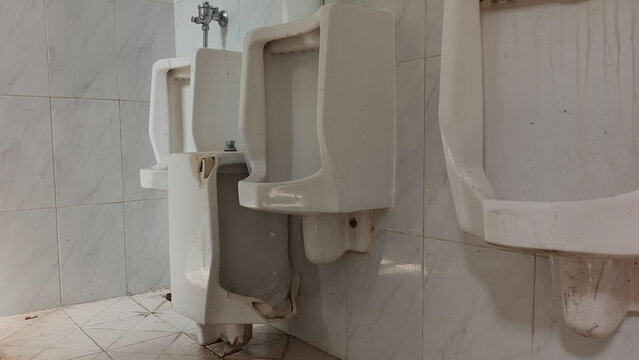 toilet in the bathroom, Broken And Shattered Ceramic Urinal On The Floor Of Dirty Public Restroom