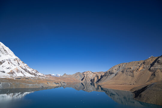 Perfect mountain reflection in the blue water of Tilicho Lake at an altitude of 4919 meters, Himalayas, Nepal