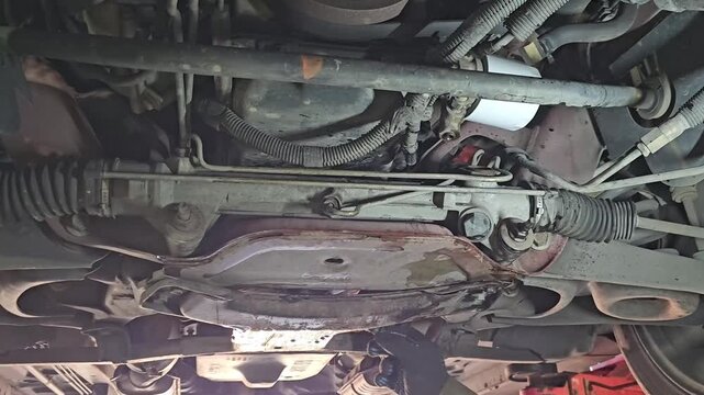 Car maintenance inspection under the vehicle focusing on parts and components