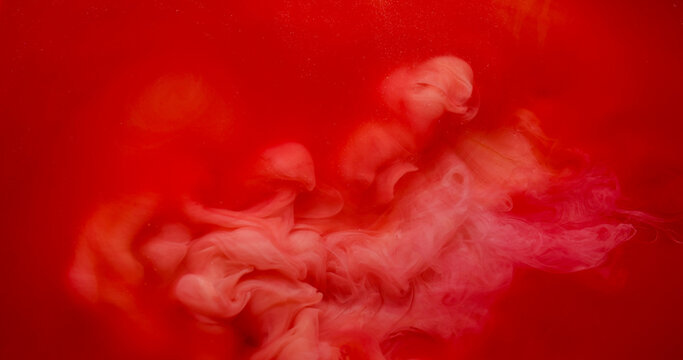 Cloud dye. Paint fog. Red orange pigment spray burst in bright watercolor liquid. Vibrant haze color blend abstract blur background.